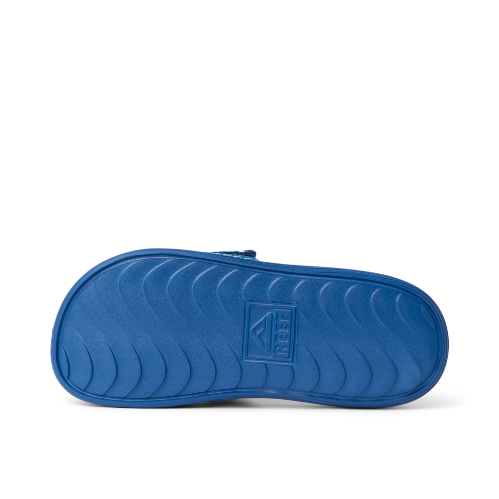 Kids Salty Slide outsole facing up, showing durable, water-friendly sole with anatomical arch support and REEF branding.