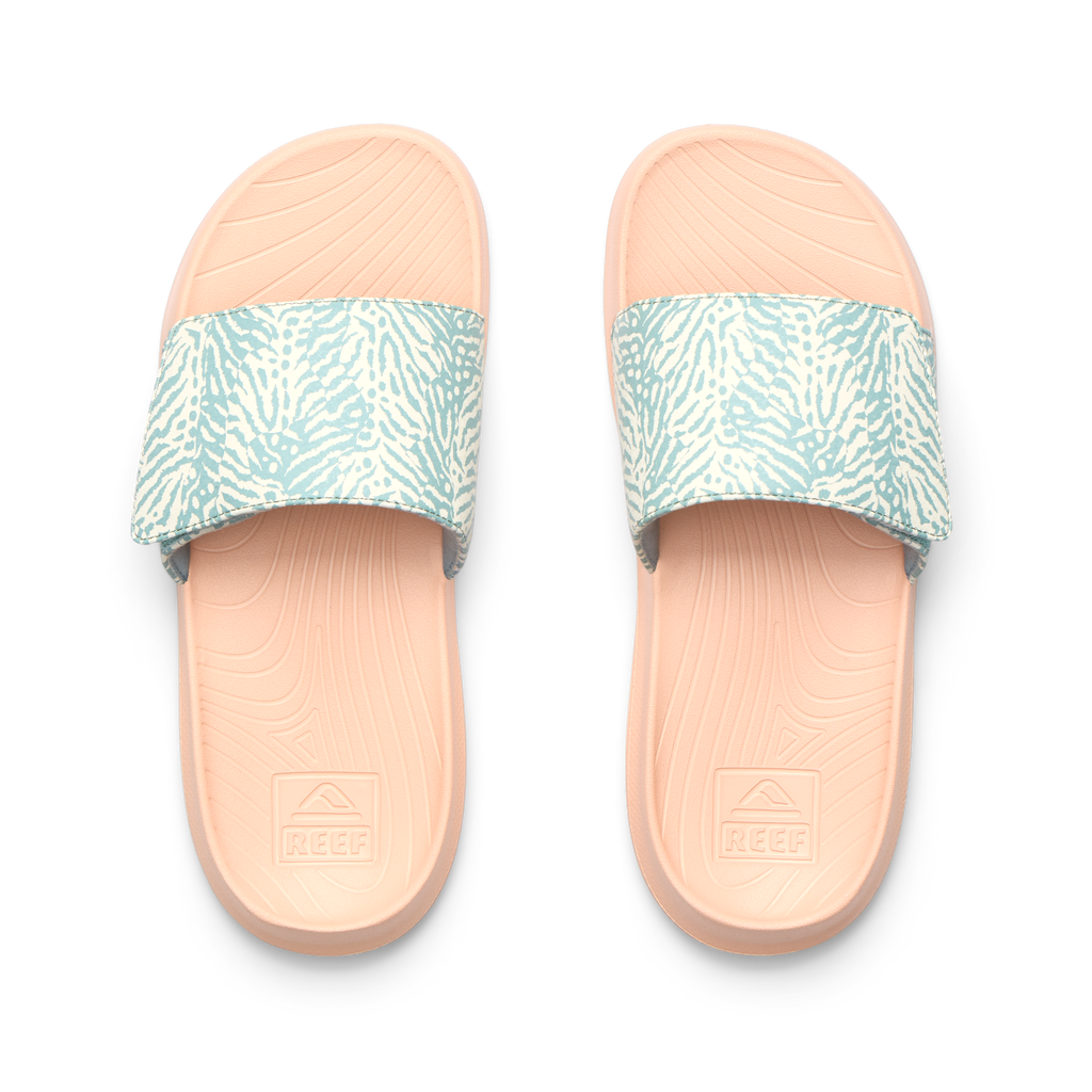 Kids Salty Slide top view showing blue patterned straps and peach cushioned footbeds with anatomical arch support, facing up.