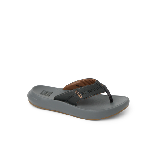 Cruiser men's sandal facing right, with brown and black straps, showing toe post and cushioned footbed for beach comfort.