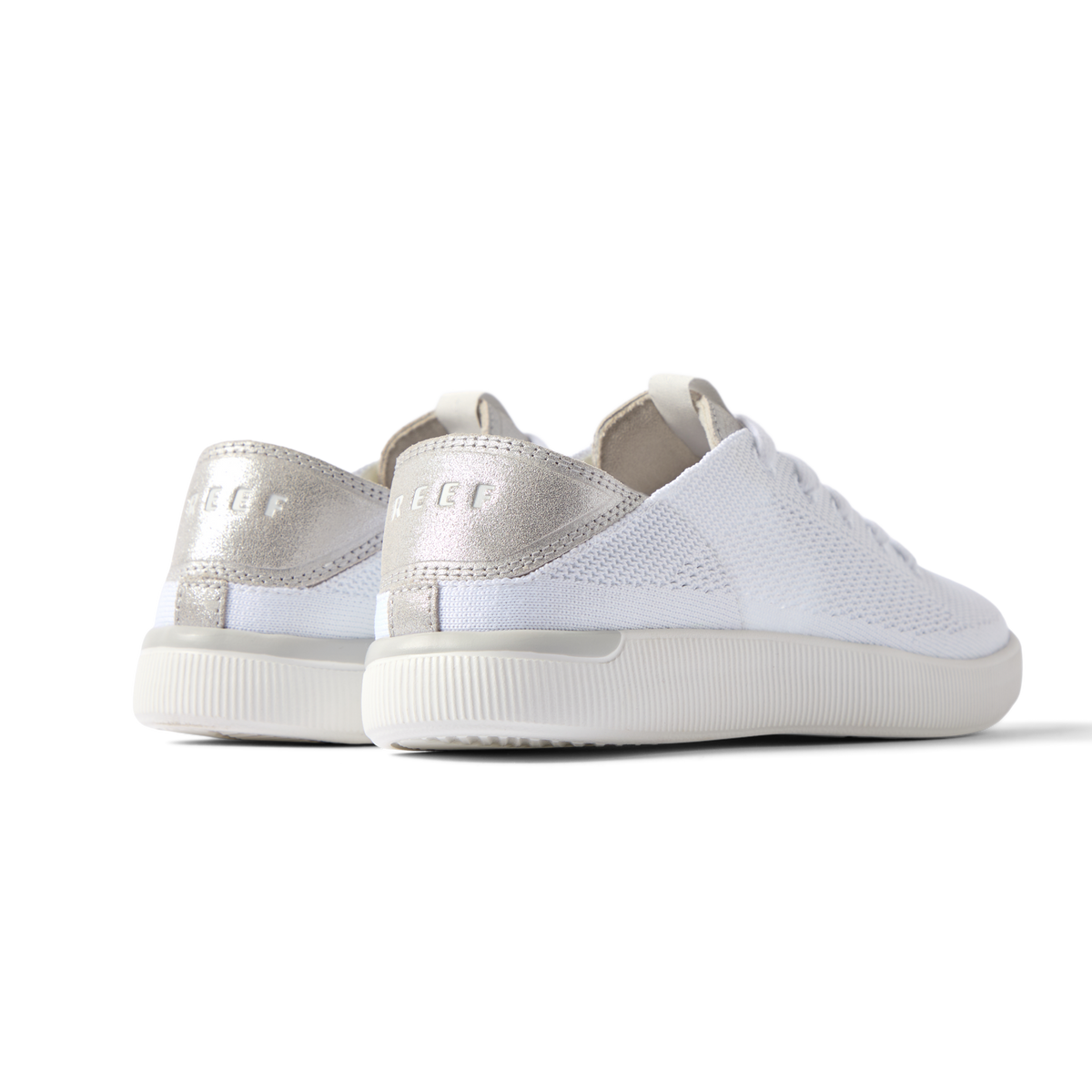 Reef Neptune women's white silver sneakers facing back left, showing cushioned heel with anatomical arch support.