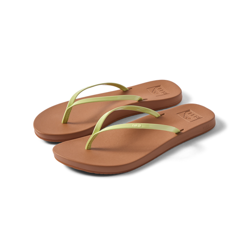 Pair of Cushion Slim women's flip flops facing right, lime green straps and brown cushioned footbed, beach-inspired comfort shoes.