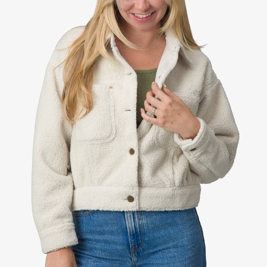Front view of a woman wearing a cream Sammie Sherpa Jacket, showcasing comfort and beach-inspired casual style.